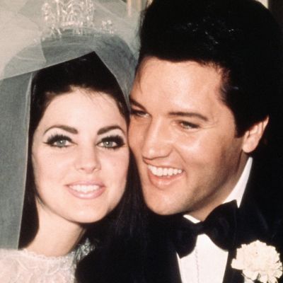 Both are in their wedding dress with smiles on their faces.